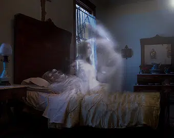 Fantôme observé près d’un lit pendant une enquête paranormale menée par Ghost Detective